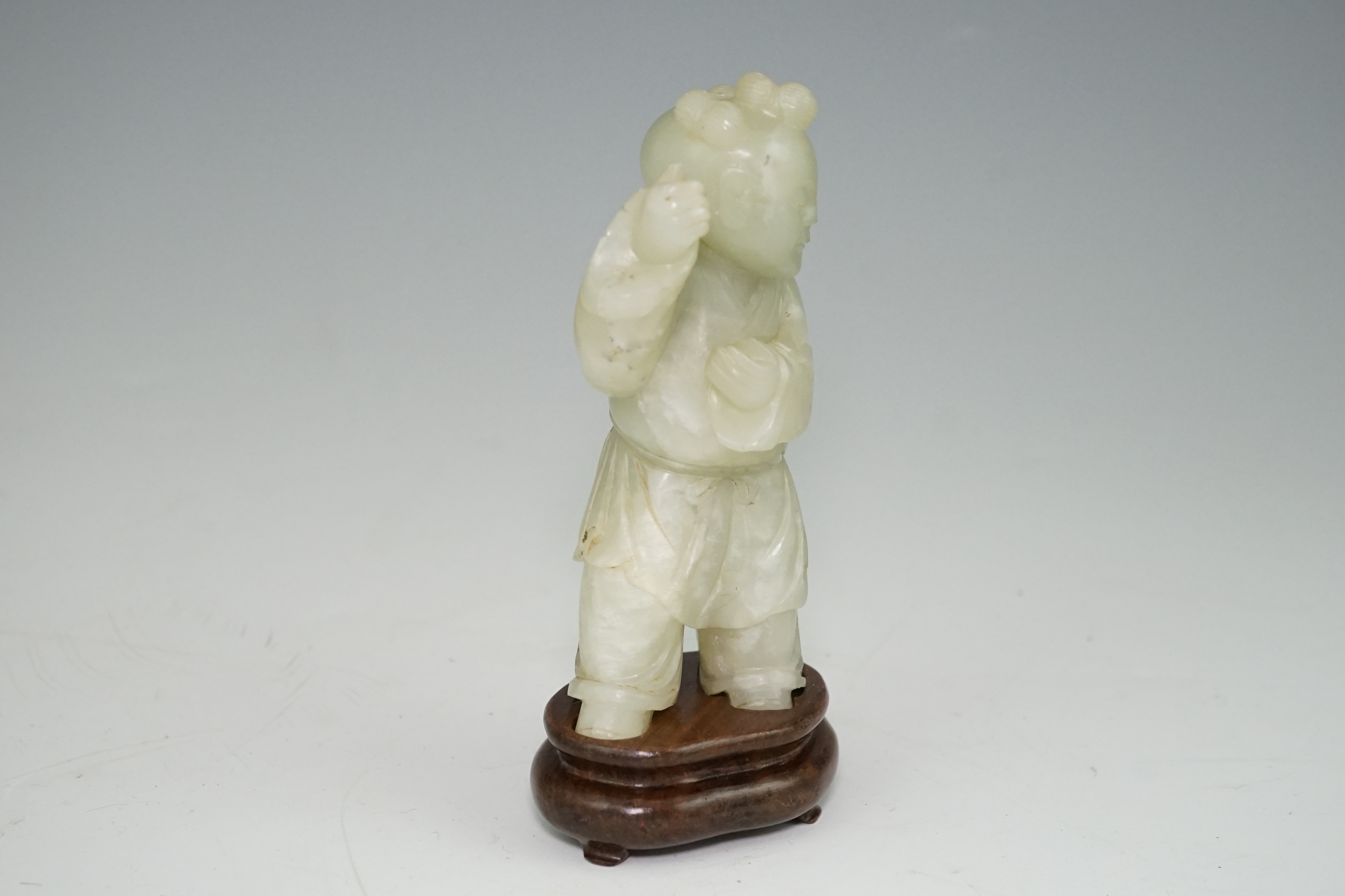 A Chinese pale celadon jade figure of a boy, 18th century